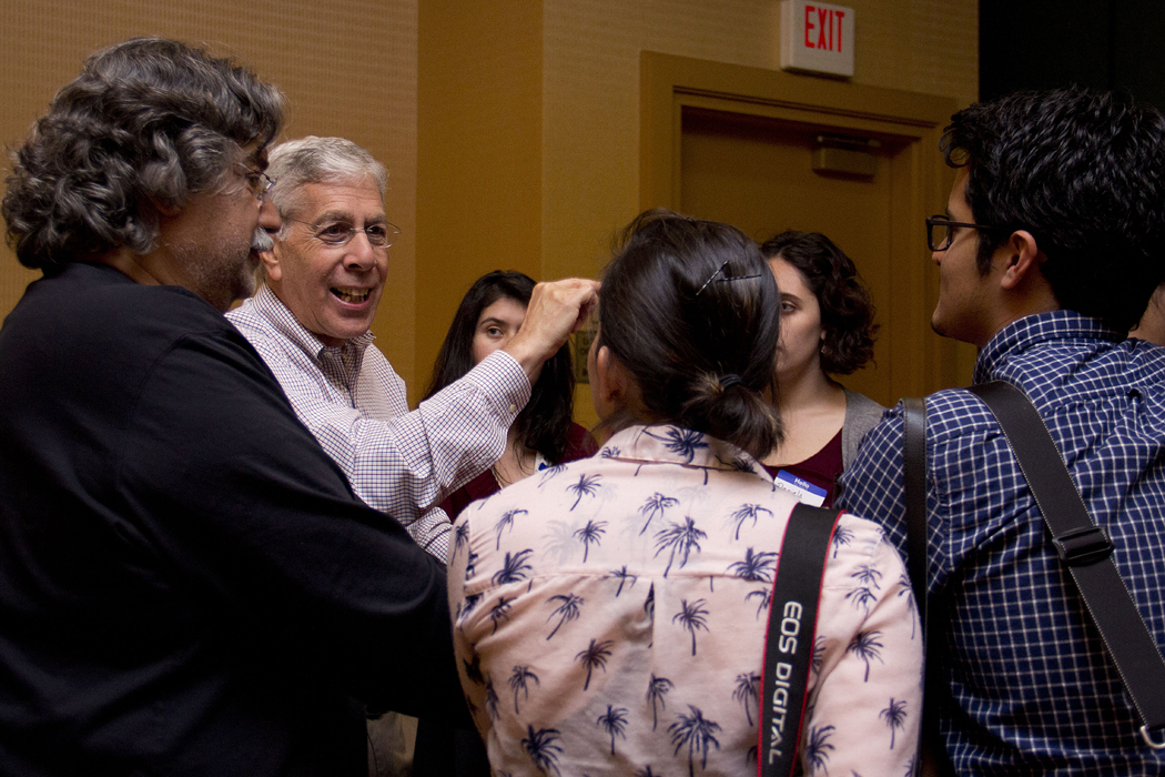 Intrigued students gather as Ángel Franco, far left, and Charles Strum, center, share anecdotes from their experiences as photographer and former associate managing editor at the Times.